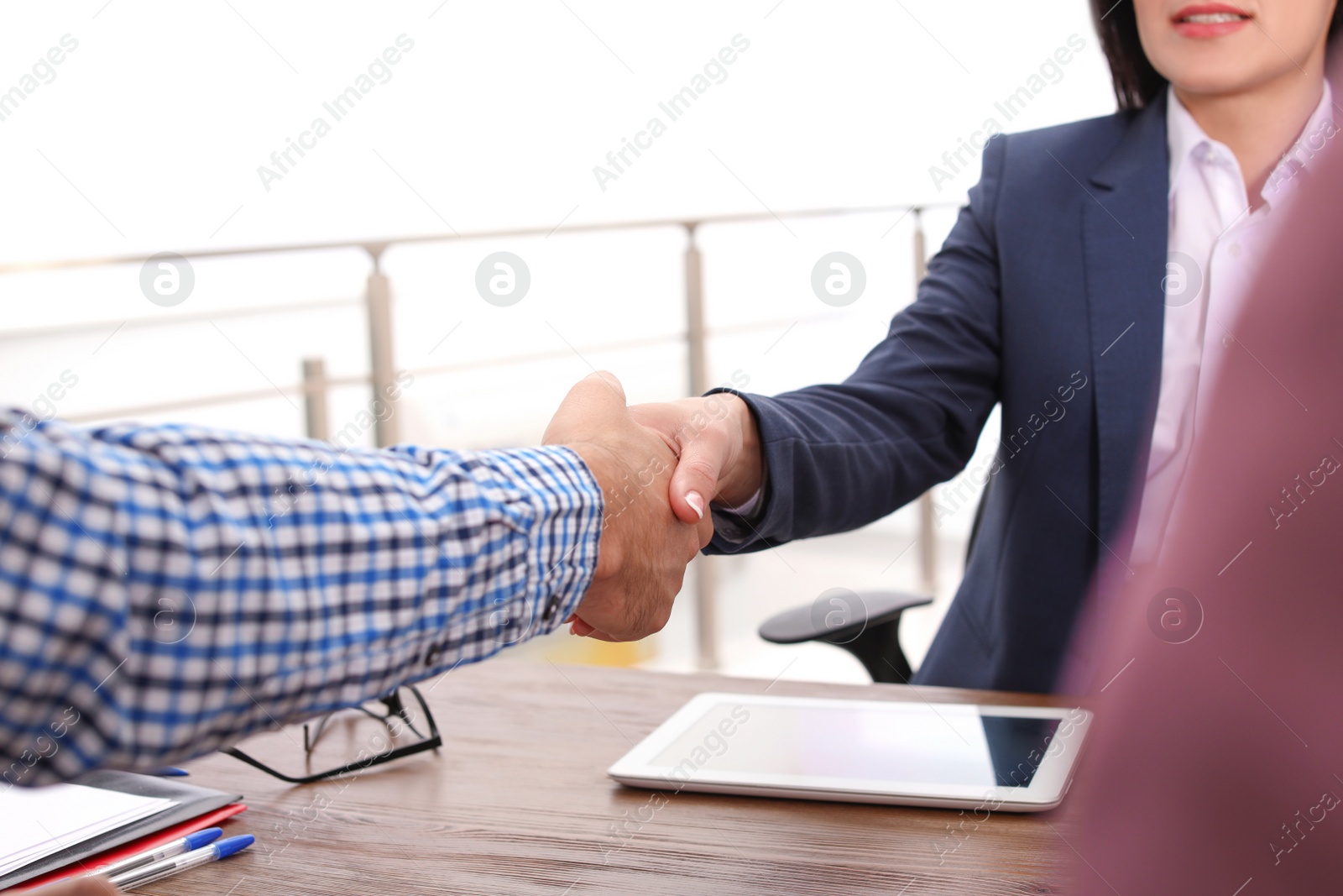 Photo of Human resources manager shaking hands with applicant during job interview in office, closeup