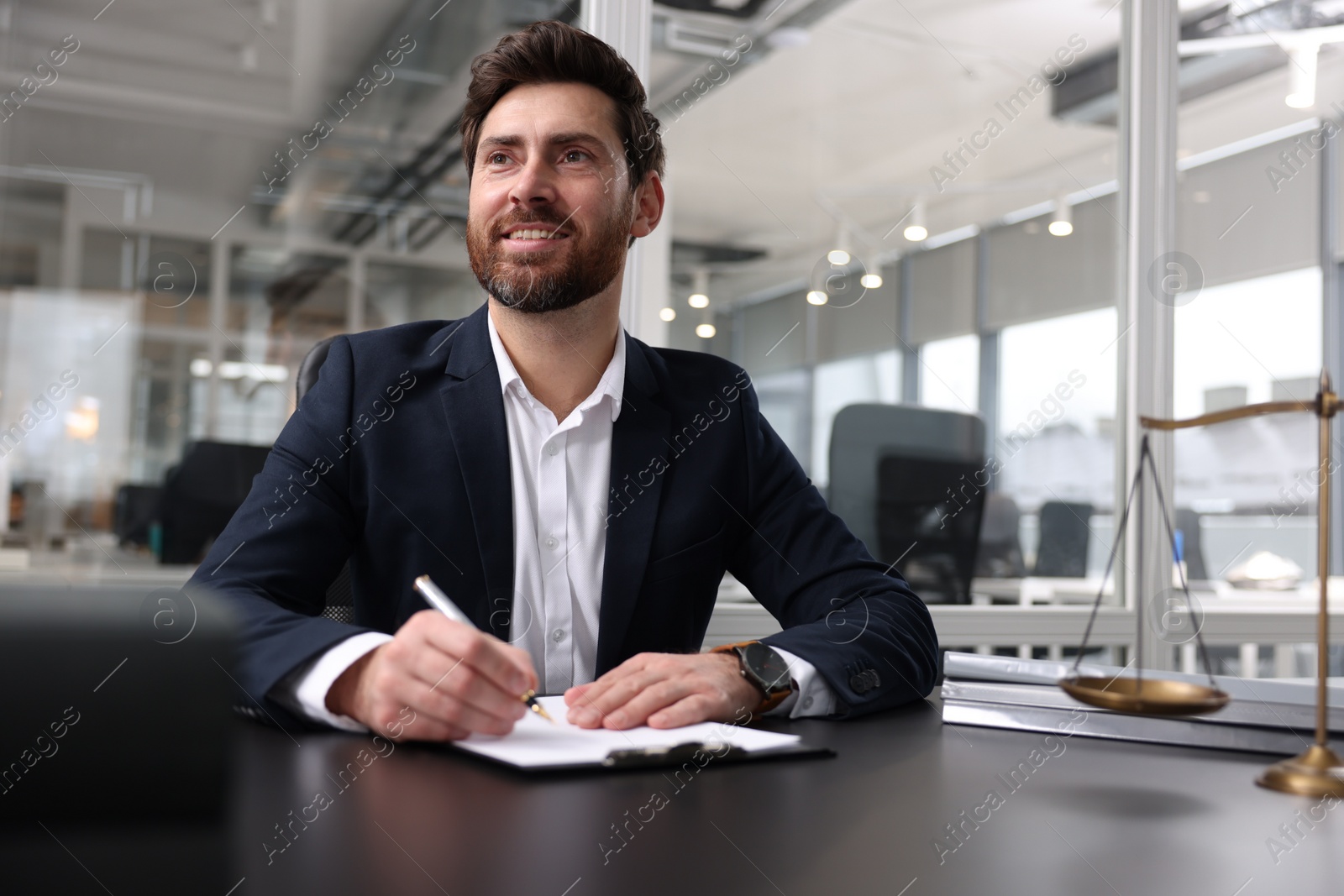 Photo of Portrait of smiling lawyer at table in office