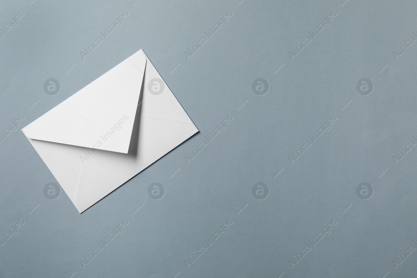 Photo of Letter envelope on grey background, top view. Space for text