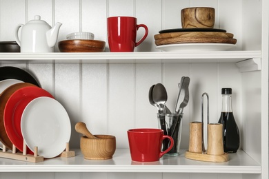 Photo of White shelving unit with set of dishware