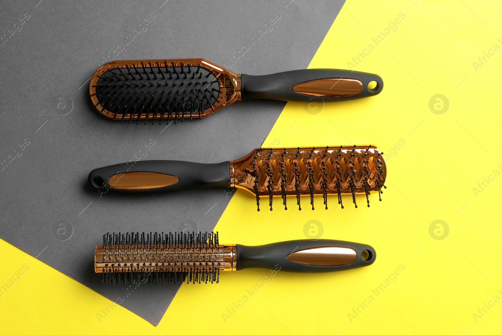 Photo of Set of hair brushes on color background, flat lay