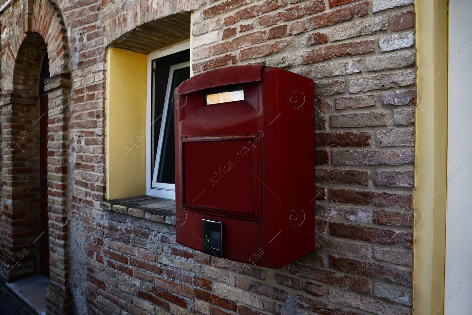 Photo of Red letter box on brick wall of building