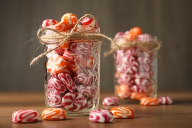 Color hard candies on wooden table. Space for text