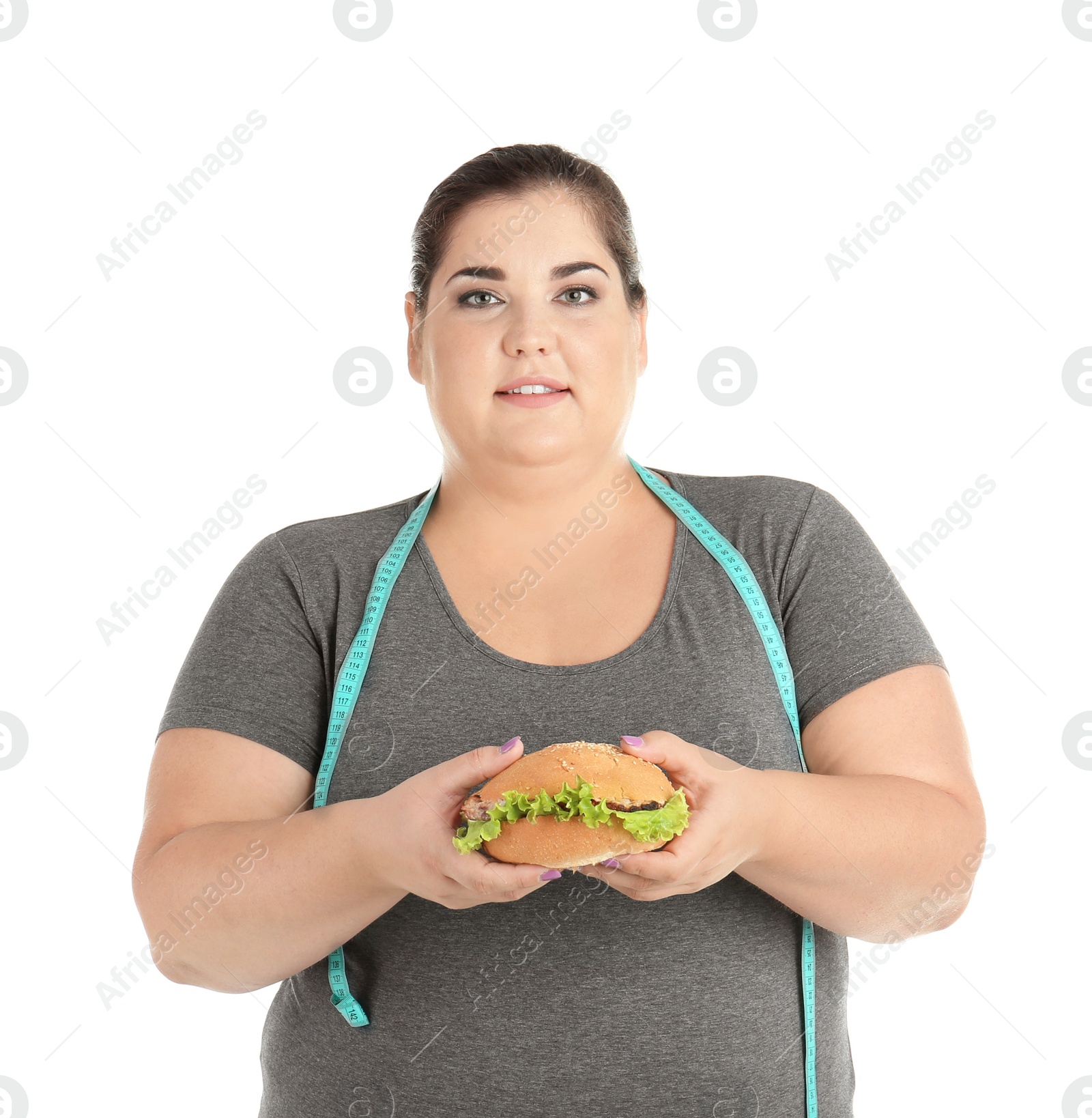 Photo of Overweight woman with hamburger and measuring tape on white background