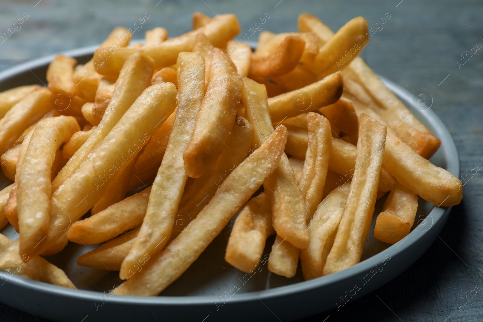 Photo of Tasty french fries on wooden table, closeup