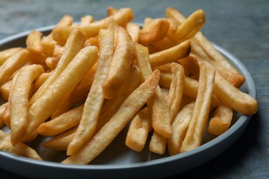 Photo of Tasty french fries on wooden table, closeup