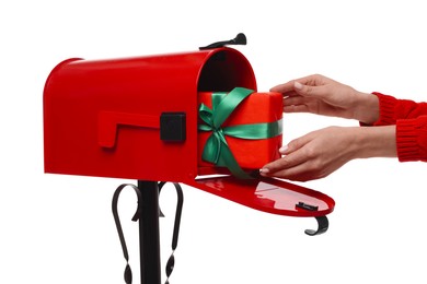 Photo of Woman putting Christmas gift into mailbox on white background, closeup. Sending present by mail