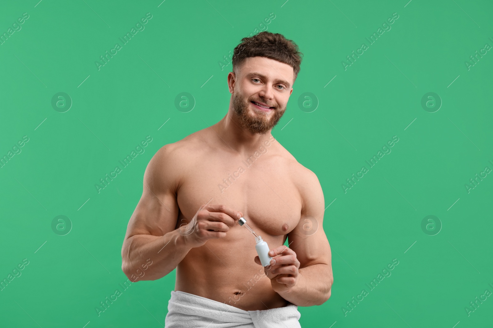 Photo of Handsome man with serum on green background