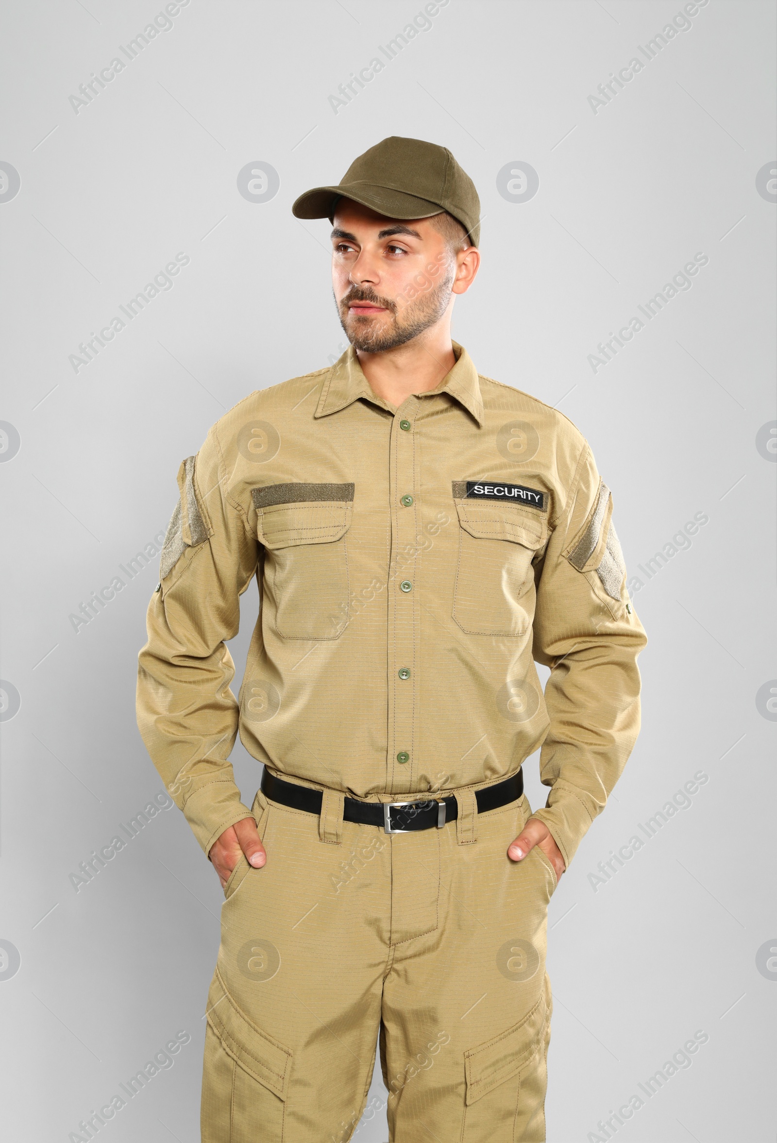 Photo of Male security guard in uniform on grey background