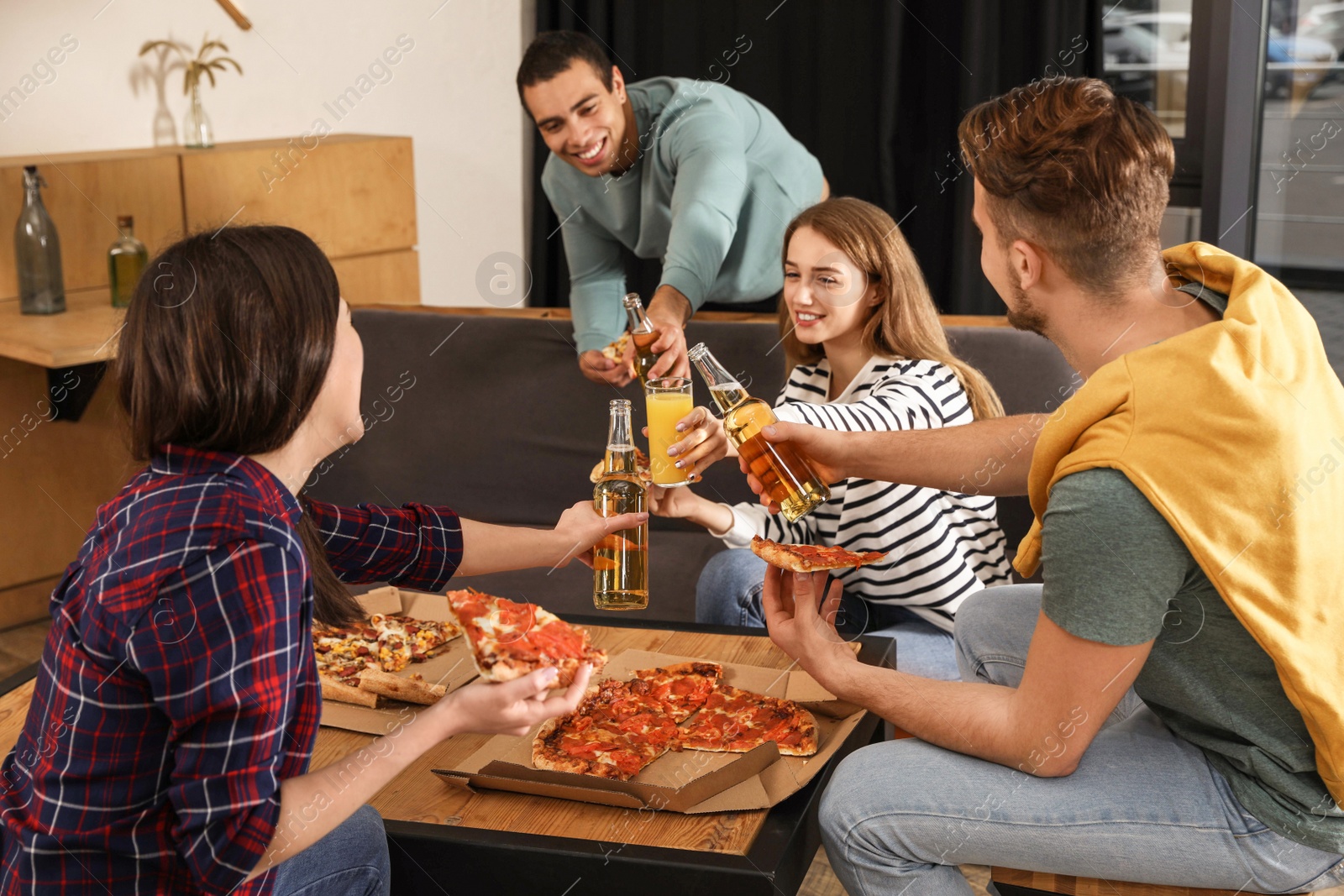 Photo of Group of friends having fun party with delicious pizza in cafe