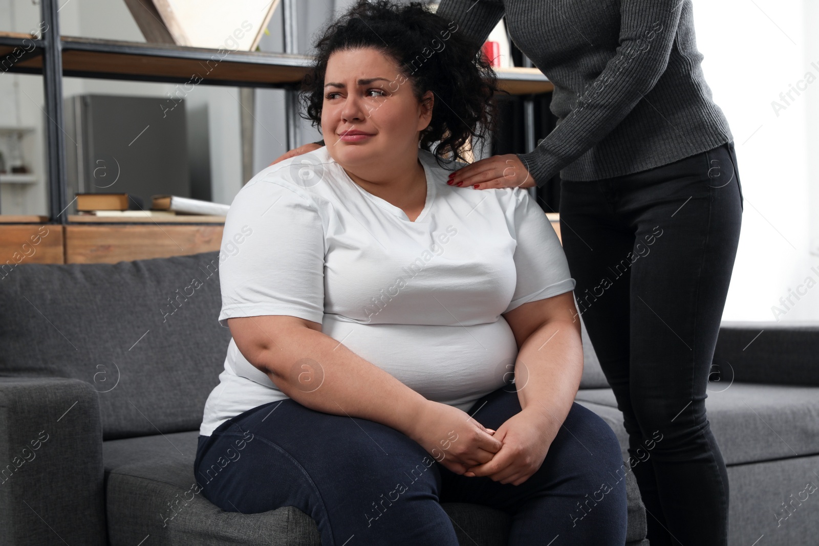 Photo of Woman comforting her depressed overweight friend at home