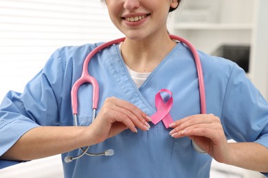 Photo of Mammologist with pink ribbon in hospital, closeup. Breast cancer awareness