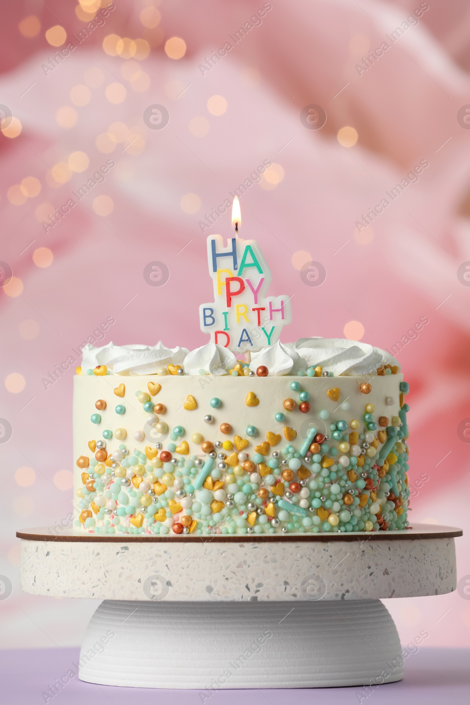 Photo of Beautiful birthday cake with burning candle on violet table