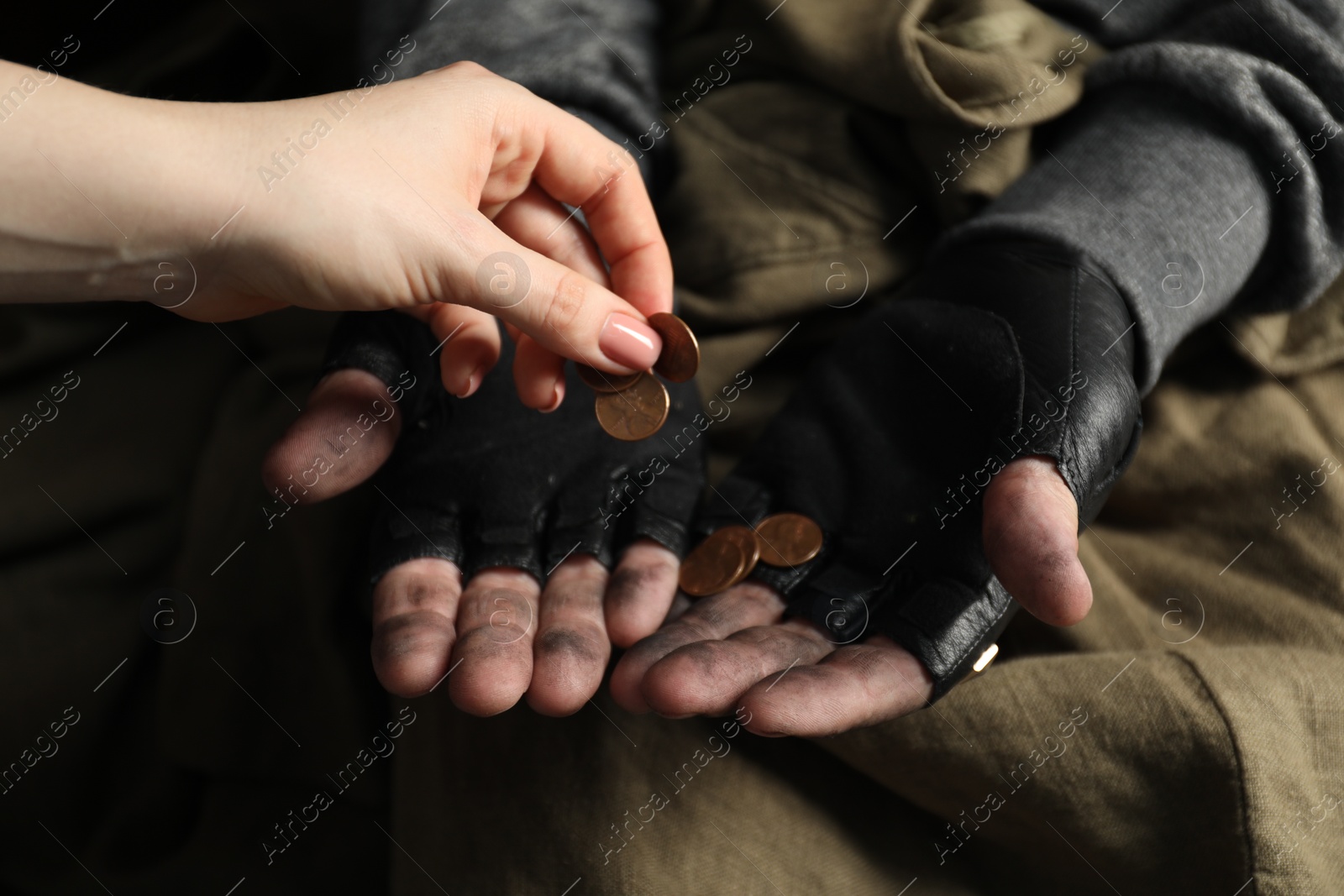 Photo of Woman giving coins to poor homeless man, closeup. Charity and donation