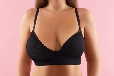Image of Woman with breast asymmetry on pink background, closeup