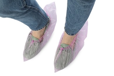 Woman wearing shoe covers onto her mules against white background, top view