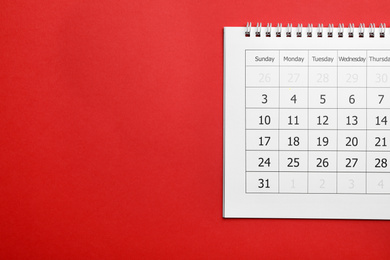 Photo of Paper calendar on red background, top view. Space for text