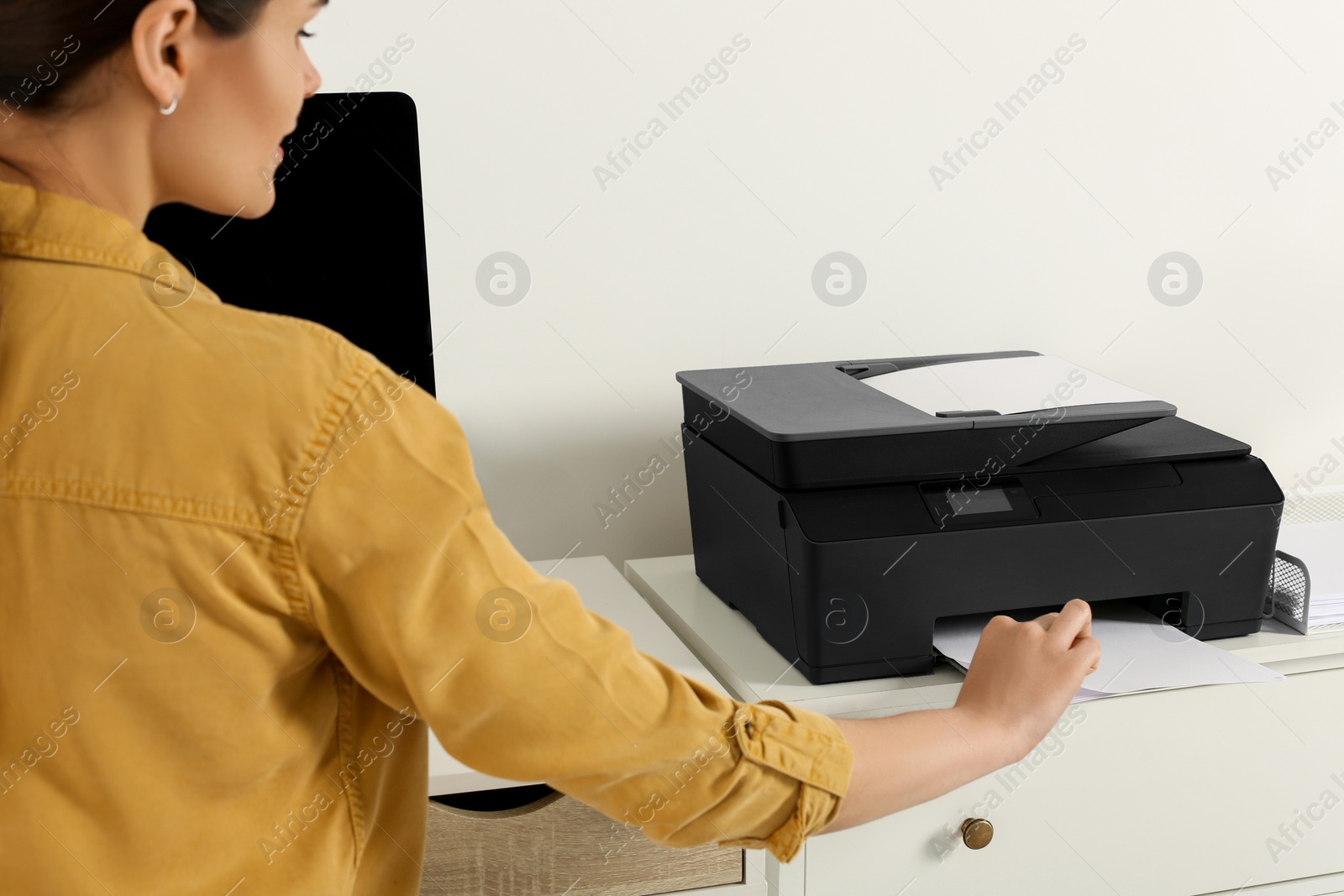 Photo of Woman using modern printer at workplace indoors