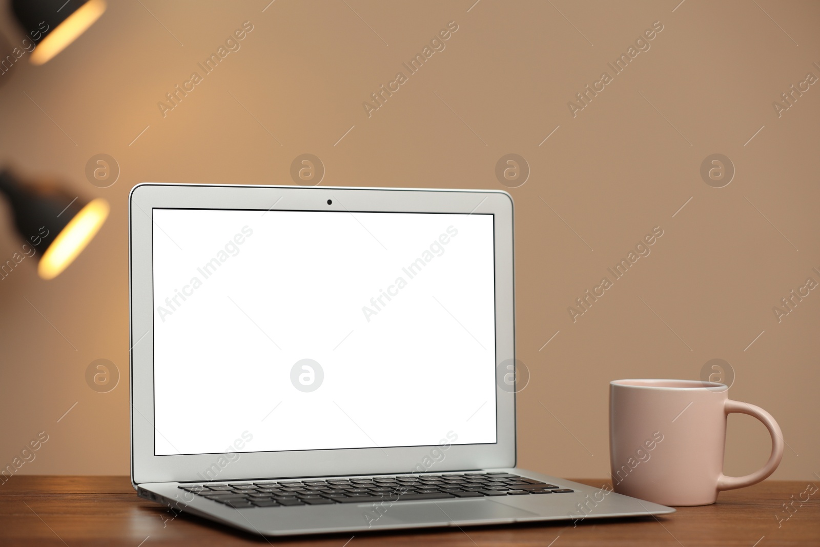 Photo of Laptop with blank screen on table indoors. Space for text