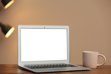 Laptop with blank screen on table indoors. Space for text