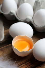 Photo of Fresh raw chicken eggs on wooden table, closeup