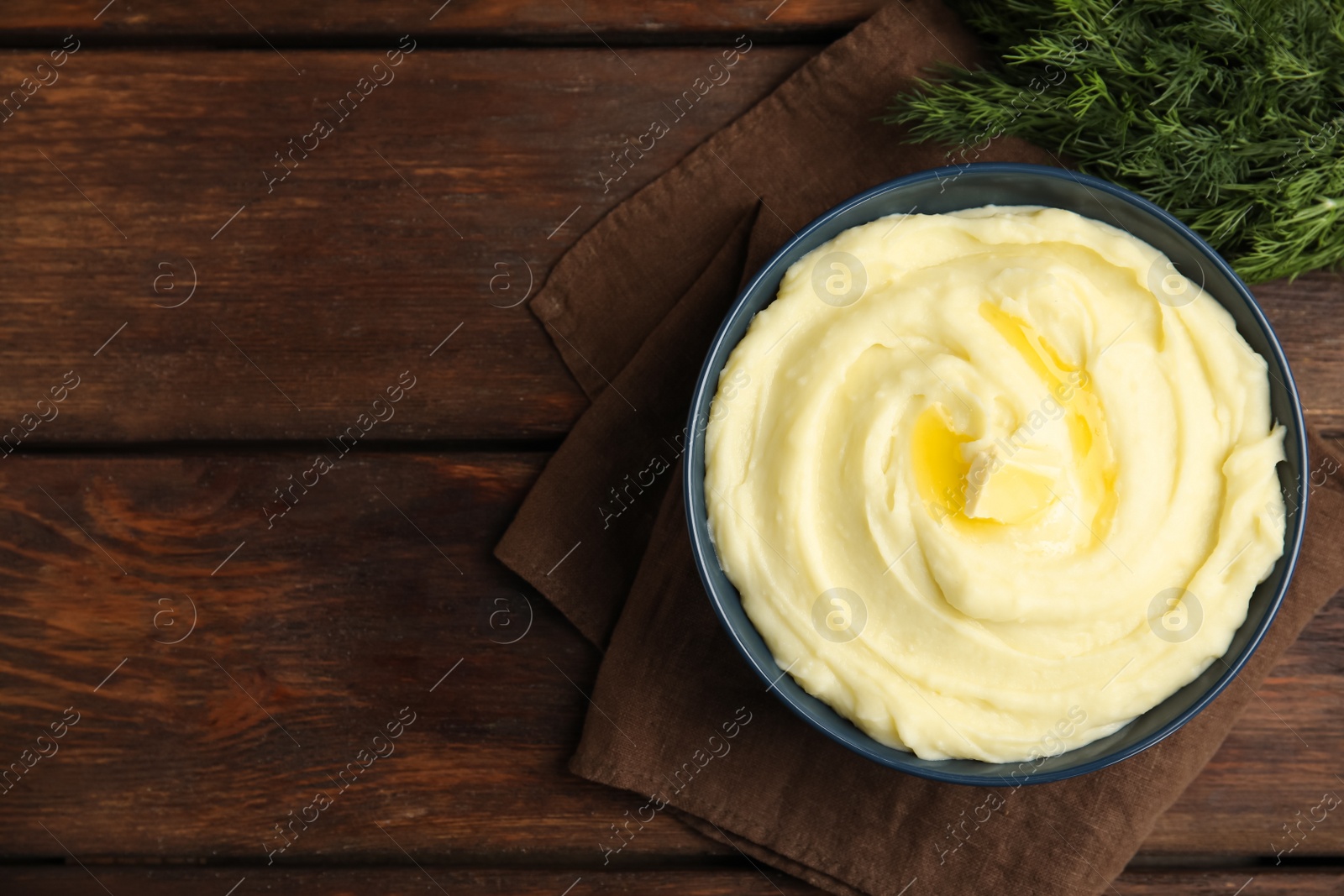 Photo of Freshly cooked homemade mashed potatoes on wooden table, top view. Space for text