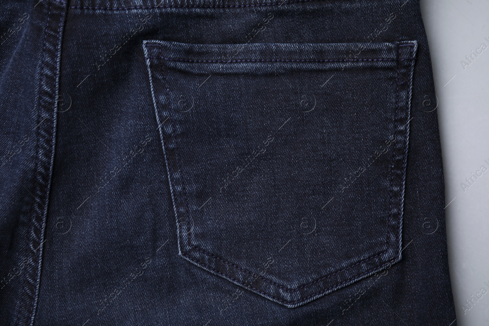 Photo of Jeans with pocket on grey background, top view