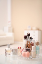 Photo of Makeup cosmetic products and tools in organizer on dressing table