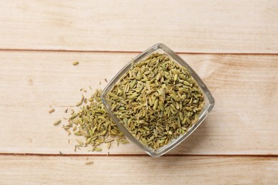 Bowl with fennel seeds on wooden table, top view