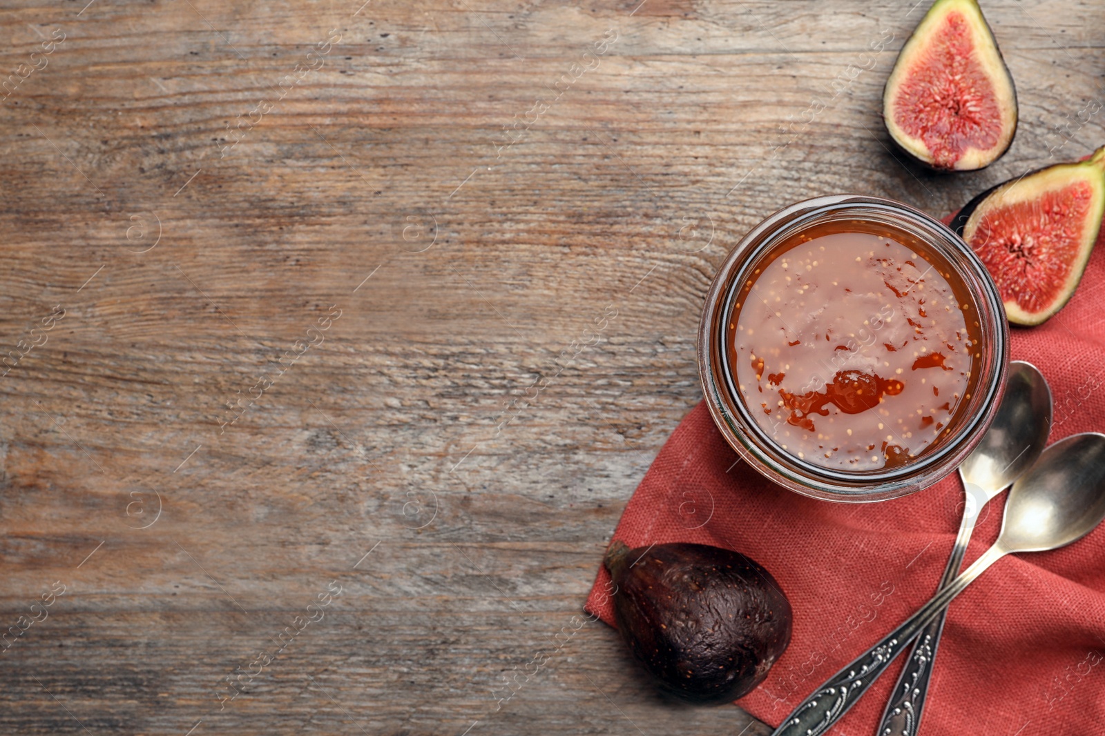 Photo of Homemade delicious fig jam on wooden table, flat lay. Space for text