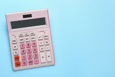 Photo of Pink calculator on light blue background, top view. Space for text