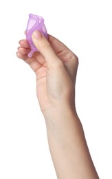 Photo of Woman folding purple menstrual cup on white background, closeup
