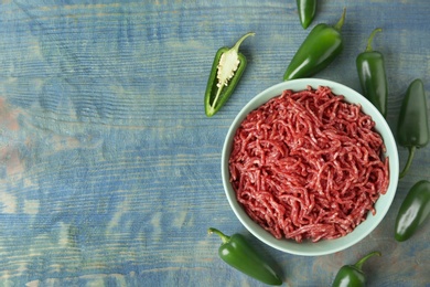 Photo of Flat lay composition with fresh raw minced meat on blue wooden table. Space for text