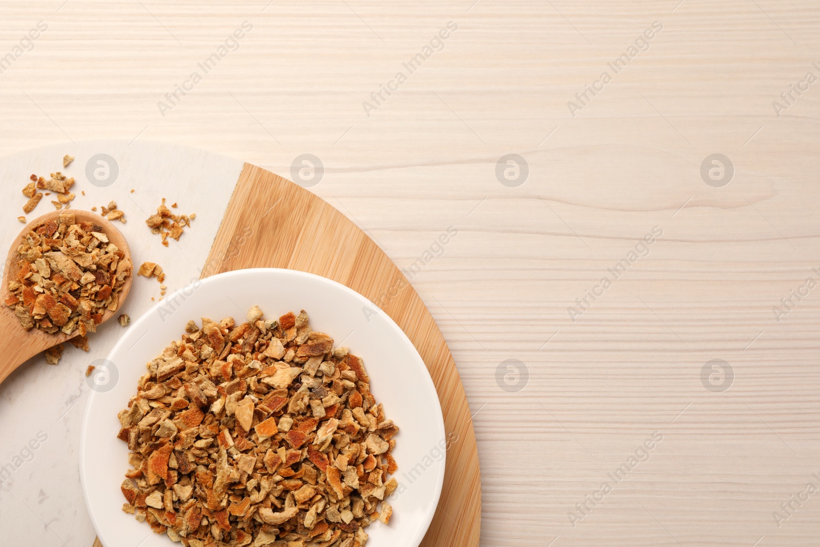 Photo of Tray with dried orange zest seasoning on wooden table, top view. Space for text