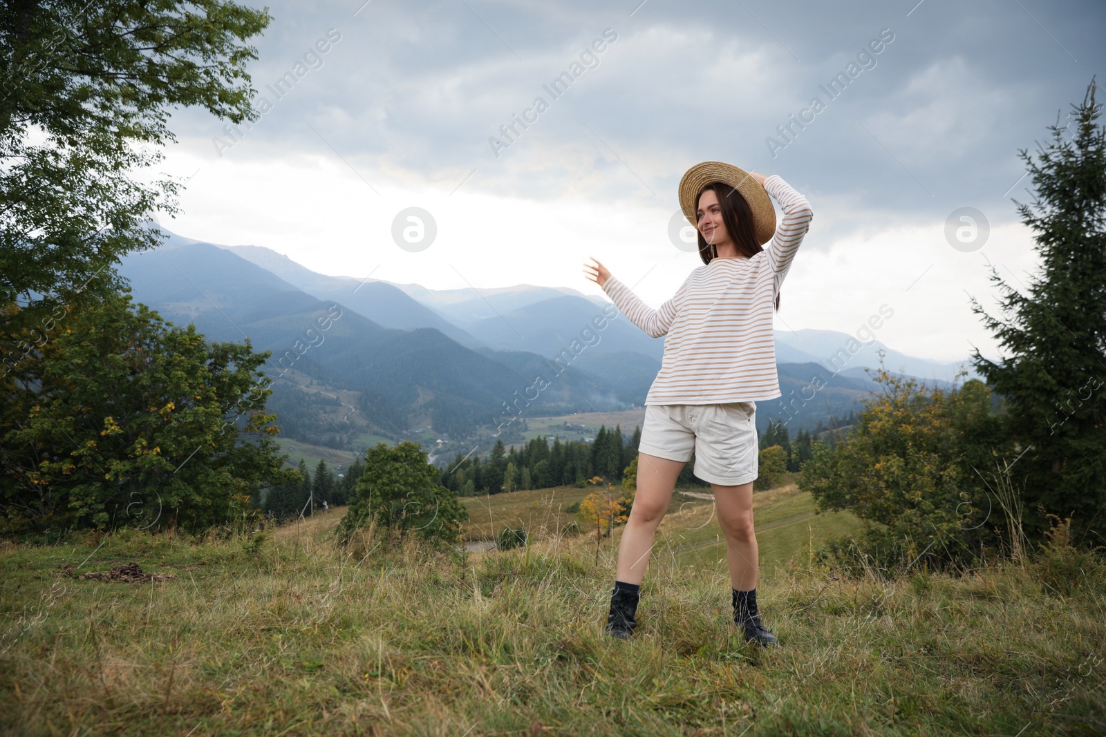 Photo of Young woman enjoying her time in mountains. Space for text