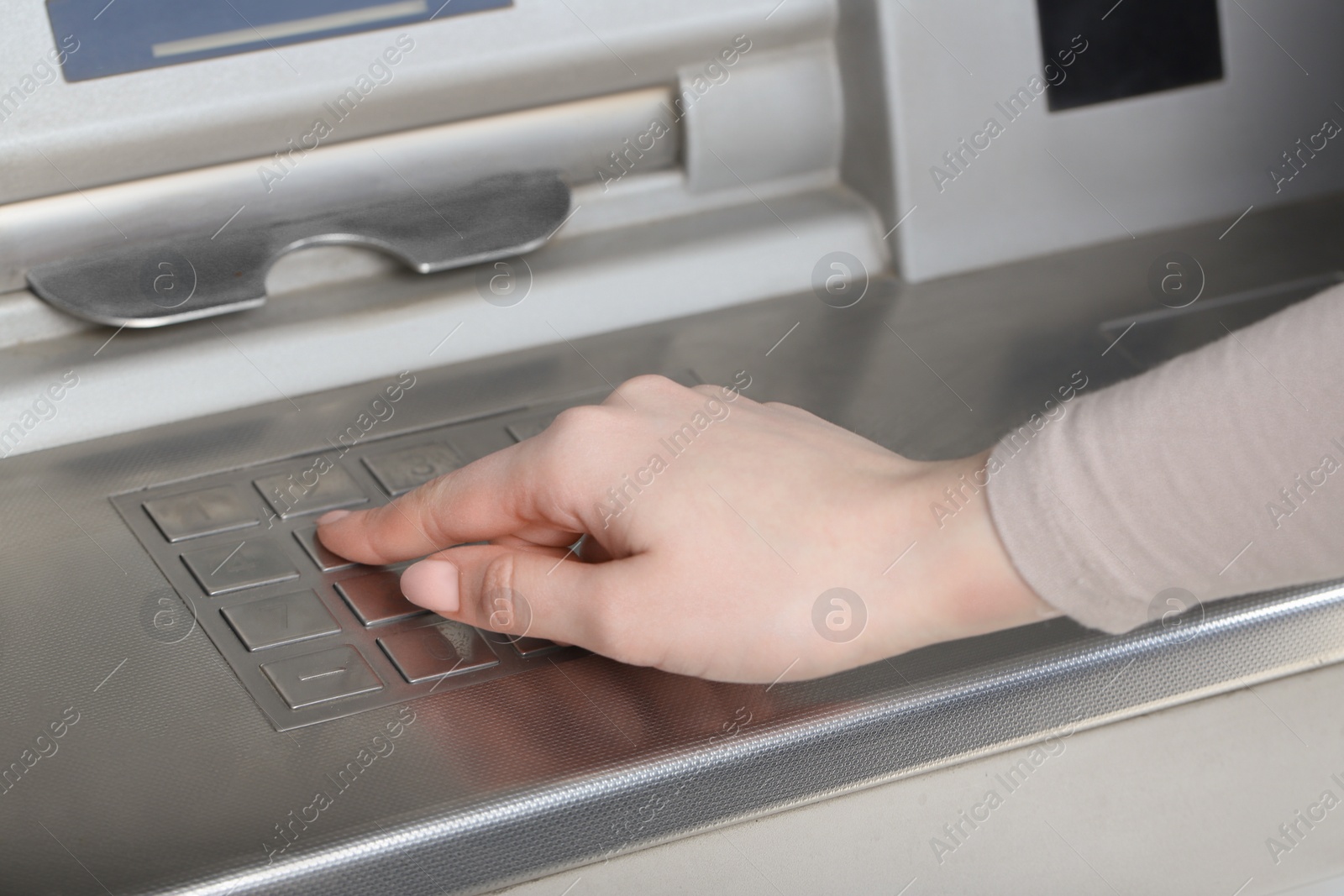 Photo of Woman using modern grey cash machine, closeup