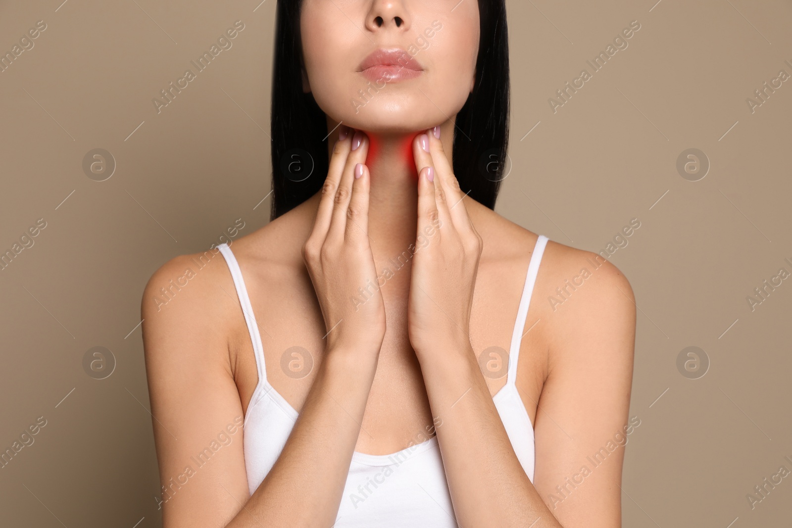 Image of Young woman doing thyroid self examination on beige background, closeup