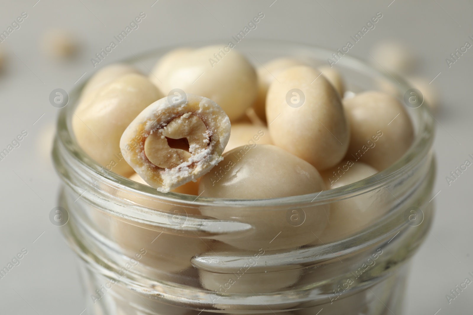 Photo of Glass jar with tasty sweets on table, closeup