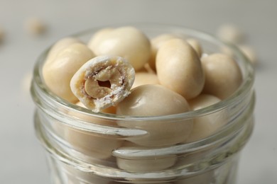 Glass jar with tasty sweets on table, closeup