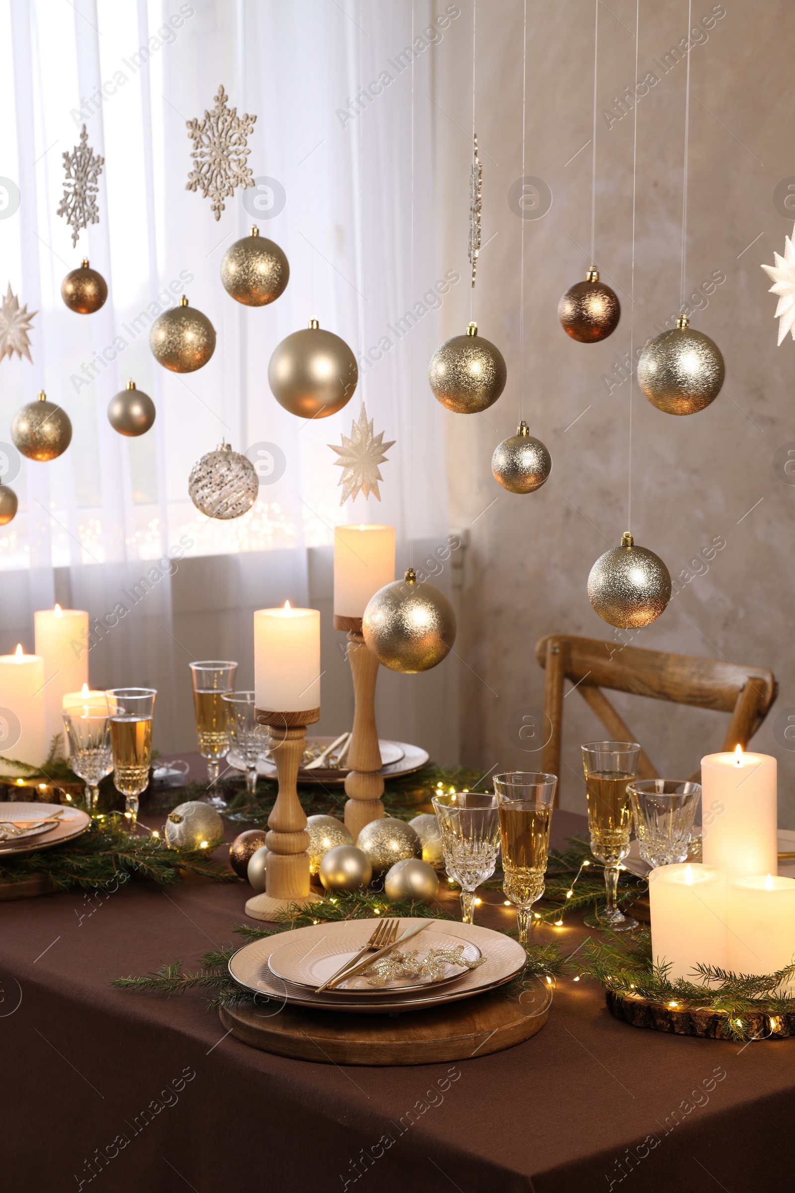 Photo of Christmas table setting with burning candles and festive decor