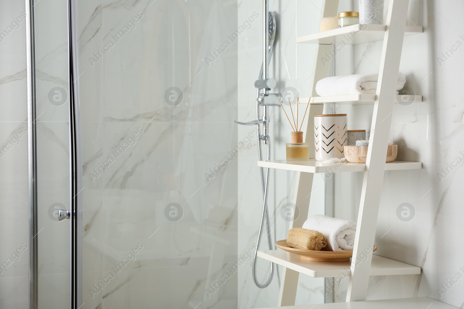 Photo of Shelving unit with different items in bathroom interior