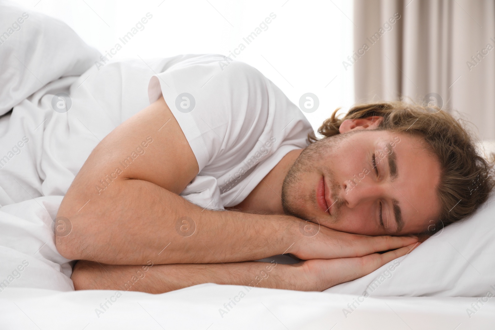 Photo of Handsome young man sleeping on pillow at home. Bedtime