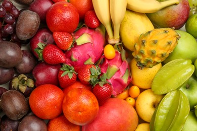 Photo of Assortment of fresh exotic fruits as background, top view