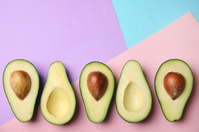 Photo of Cut fresh ripe avocados on color background, flat lay with space for text