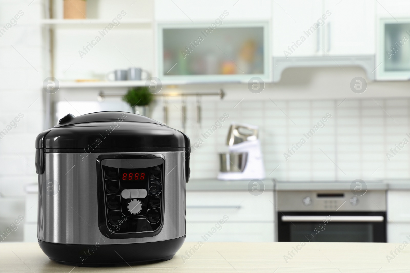 Photo of Modern multi cooker on table in kitchen. Space for text