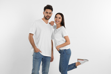 Photo of Young couple in stylish jeans near white wall