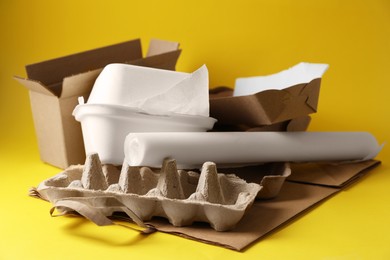 Heap of waste paper on yellow background