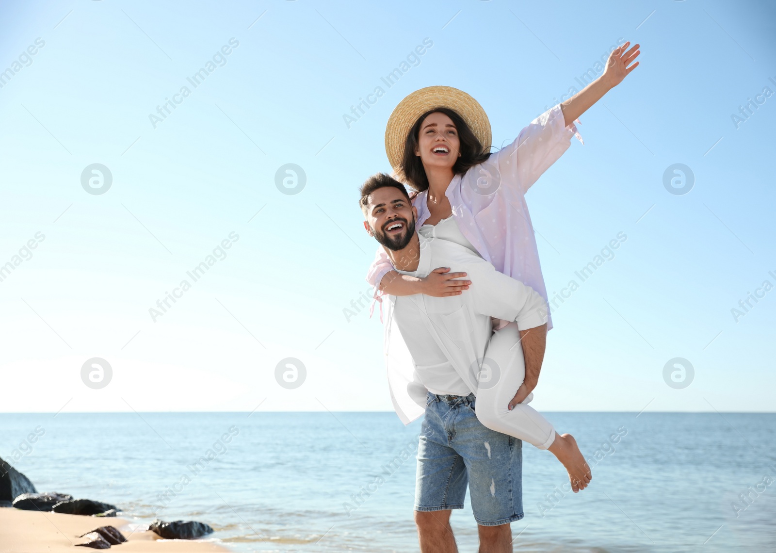 Photo of Happy young couple having fun at beach near sea. Honeymoon trip