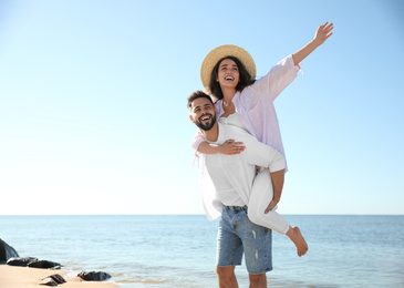Photo of Happy young couple having fun at beach near sea. Honeymoon trip