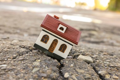 Photo of House model in cracked asphalt. Earthquake disaster